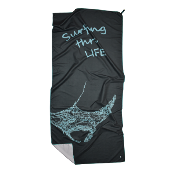 CANYLA XL Microfiber Beach Towel, curvy, blue, showing text "Surfing thru LIFE", and the drawing of a manta ray. Bottom left corner is folded over.