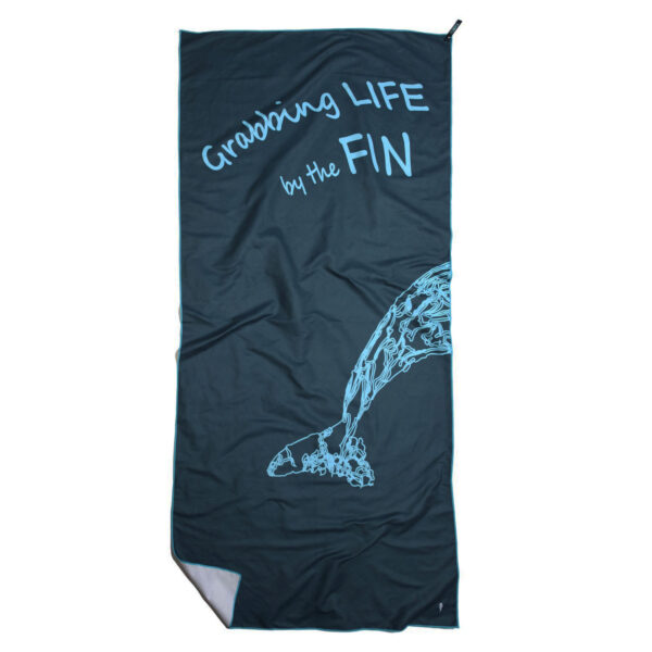 CANYLA XL Microfiber Beach Towel, curvy, blue, showing text "Grabbing LIFE by the FIN", and the drawing of tail of a humpback whale. Bottom left corner is folded over.